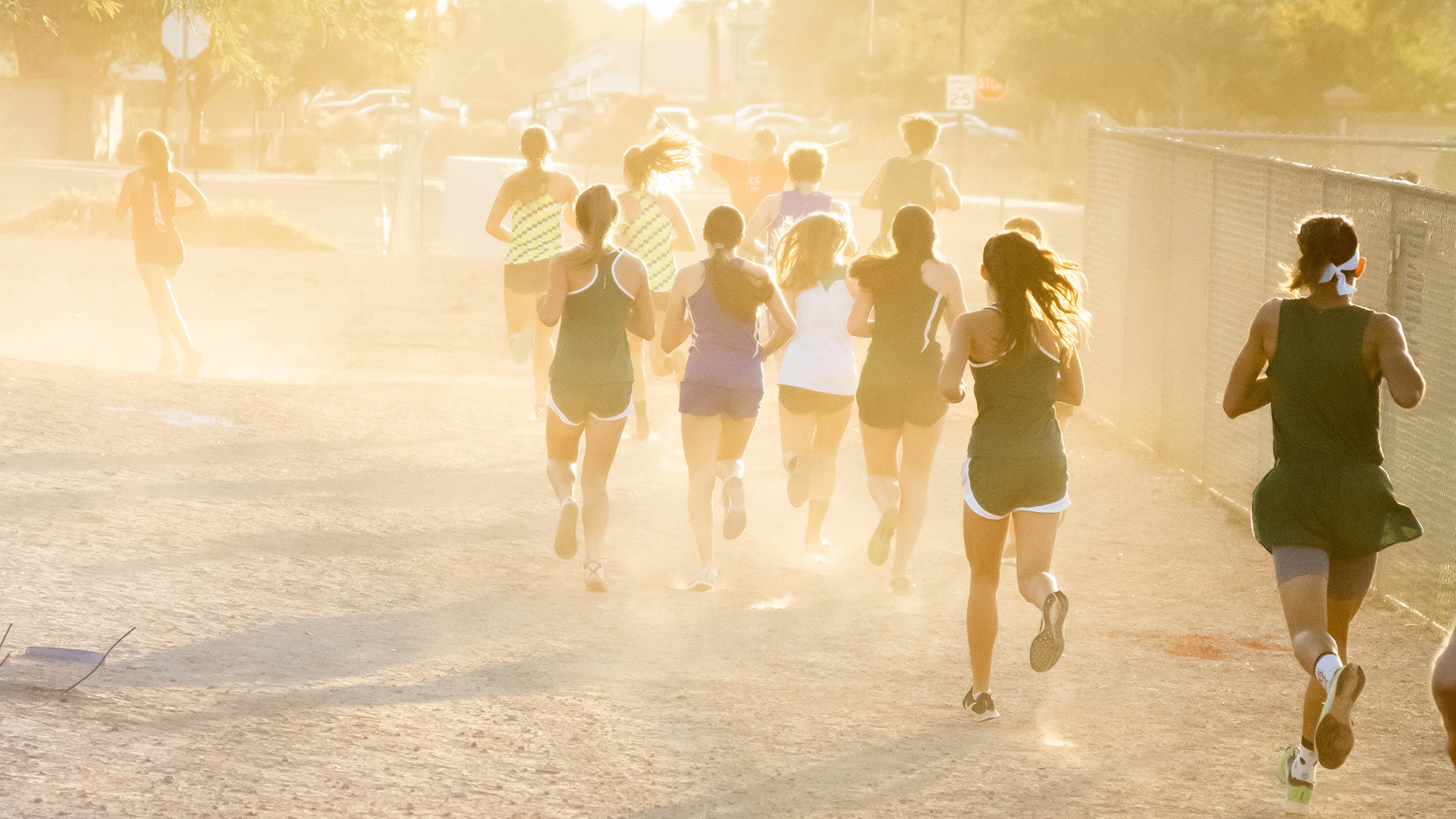 Grupo de personas corriendo en un campo de tierra